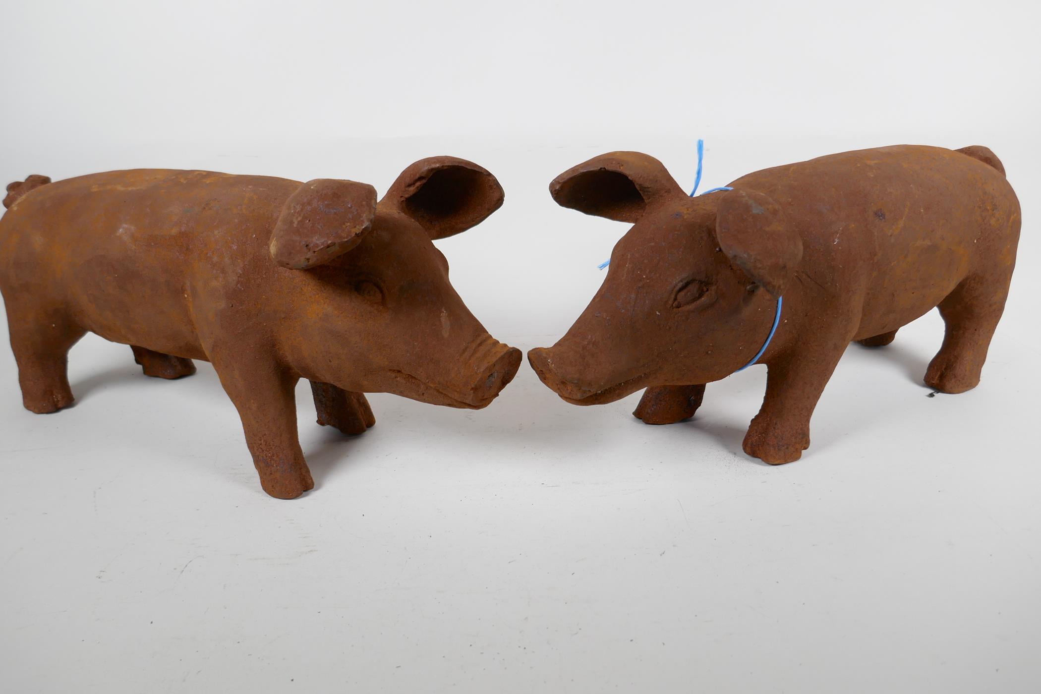 Two cast iron garden figures of pigs, 17" long
