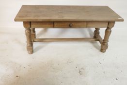 A bleached oak coffee table, with single drawer raised on turned supports united by an 'H'