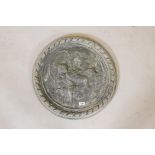 A concrete wall plaque with raised decoration of putti riding dolphins, 22" diameter