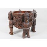 An ethnic carved wood bowl supported by four figures, 7" diameter, 7½" high