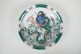 A Chinese famille verte porcelain charger decorated with a dragon and the flaming pearl, 6 character