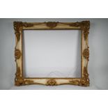 A gilded gesso and aged cream paint effect frame, with carved scrolling foliage (A/F), 30" x 25"