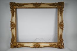 A gilded gesso and aged cream paint effect frame, with carved scrolling foliage (A/F), 30" x 25"