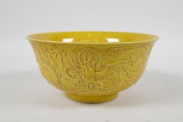 A Chinese yellow ground porcelain rice bowl with raised dragon decoration, 6 character mark to base,