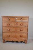 A Victorian stripped pine chest of two over three drawers, with wood handles and shaped apron,