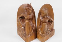 A pair of Balinese hardwood bookends carved as male and female figures, 8" high