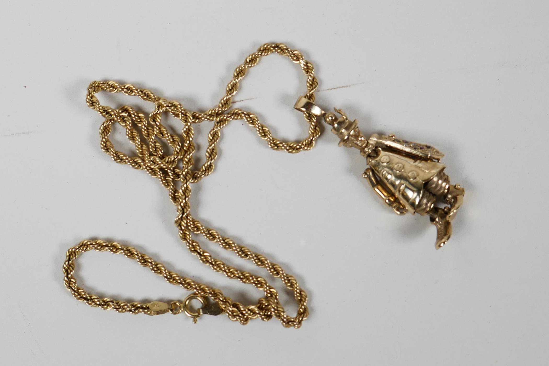 A 9ct gold pendant in the form of a clown, with articulated limbs and tie set with rubies and