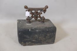An antique wrought iron bootscraper mounted on a painted stone base, 12" x 8" x 13"