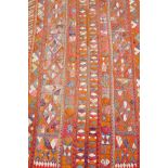 A antique Indian orange ground wool rug, with a unique floral patterned design, 98" x 60"