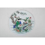 A Chinese famille verte porcelain circular plaque decorated with women and children in a