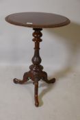 A Victorian figured walnut lamp table, the top with carved edge, raised on a turned baluster