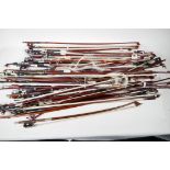 A box containing over fifty violin bows, varying lengths, mostly for restoration