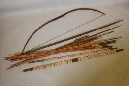 A collection of tribal longbows and spears, most with bamboo shafts and all with wood tips,