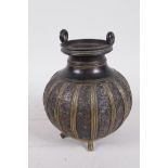 An Oriental bronze vase with two handles to the rim, the body engraved with floral panels and raised
