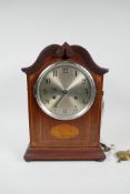 An Edwardian inlaid mahogany mantel clock, with silvered dial and spring driven movement, striking