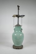 A Chinese celadon glazed two handled vase converted to a lamp with a pierced metal base and
