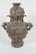 An archaic bronze jar and cover, the bulbous body with two mythical animal head handles and all over