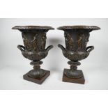 A pair of classical Grand Tour style bronze pedestal urns decorated with many figures on square