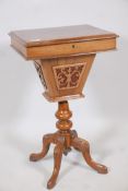 A Victorian walnut workbox with lift up top and pierced basket, raised on a turned column and carved