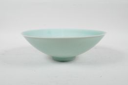 A Chinese celadon glazed porcelain bowl, with incised decoration of peaches and boys, 8" diameter
