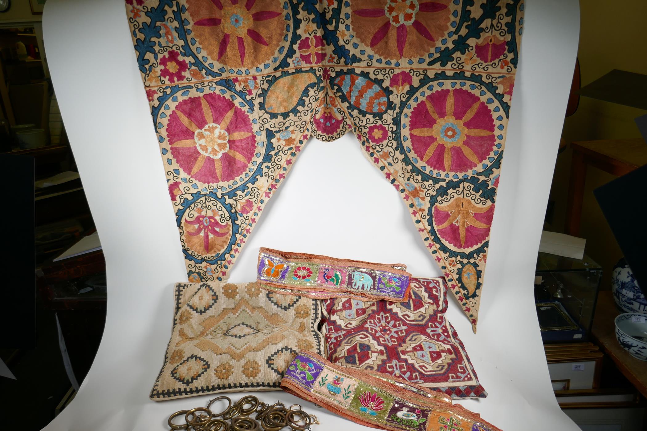 A Vintage Uzbekistan suzani embroidered door drape, an Indian pelmet, two Uzbekistan suzani cushions