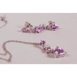 A 10ct white gold necklace with pink sapphire heart shaped pendant and matching drop earrings