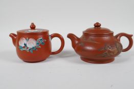 A Chinese Yixing teapot with raised and painted landscape decoration, and another with enamelled