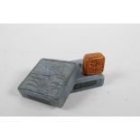 A Chinese green soapstone box containing an amber soapstone seal, the cover with carved lotus flower