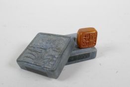 A Chinese green soapstone box containing an amber soapstone seal, the cover with carved lotus flower