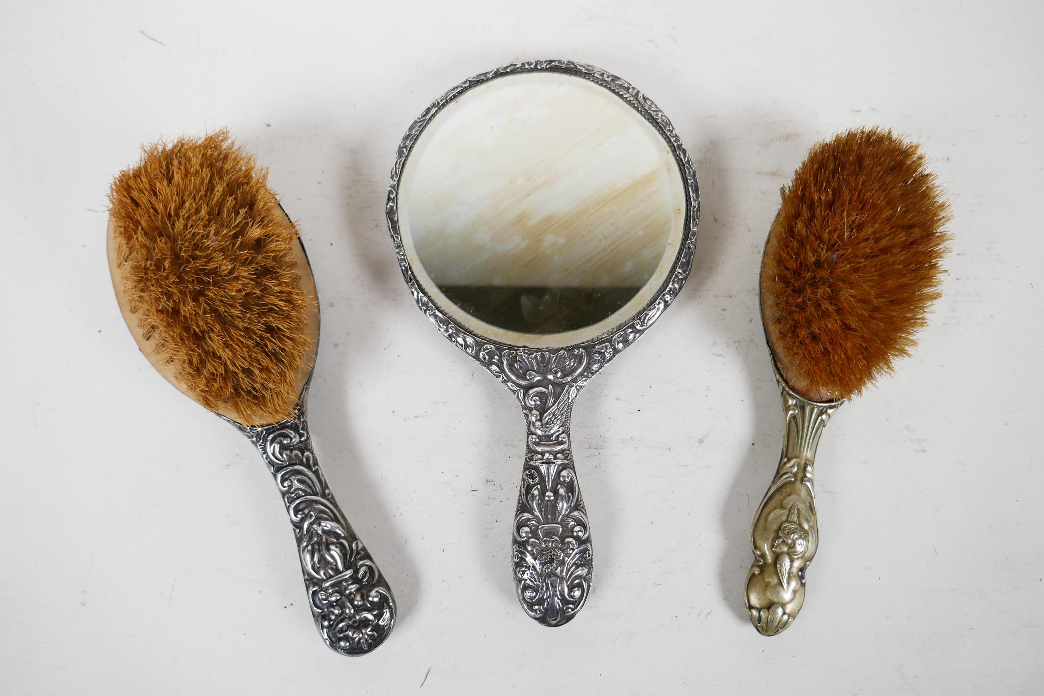 A silver backed late C19th mirror and brush dressing table set, with repousse scrolls, birds and - Image 7 of 7