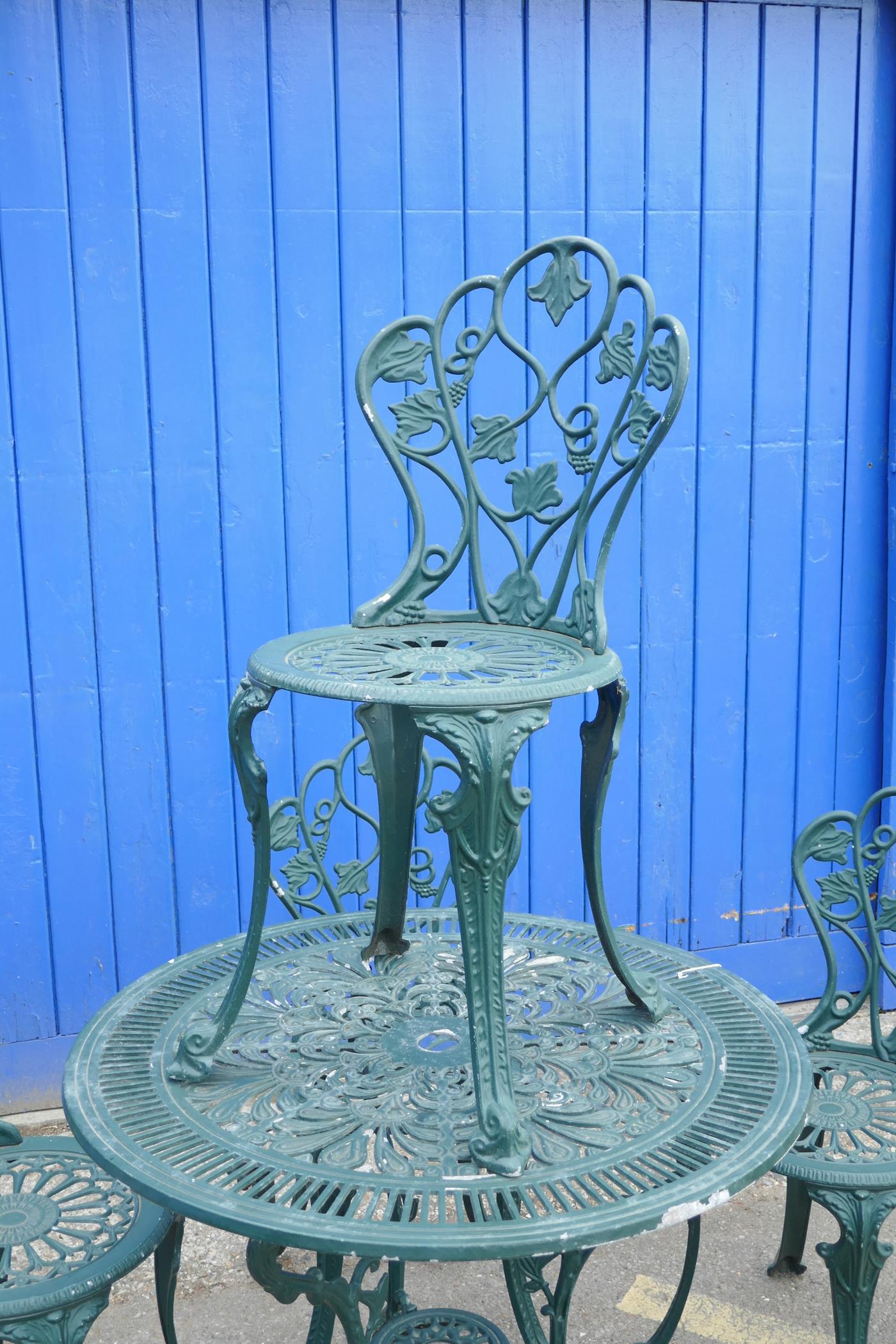 A cast aluminium garden table and chairs, the circular table with pierced decoration and three leg - Image 3 of 3