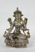 A Sino-Tibetan silvered metal deity seated on a lotus throne, 8" high
