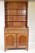 An Arts and Crafts oak one piece cottage dresser with rack, the single drawer with moulded detail