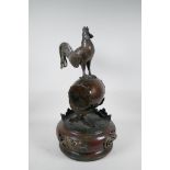 A Japanese Meiji (1868-1912) bronze of a cockerel standing on a war drum, the base with pierced