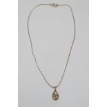A 9ct yellow gold pendant necklace set with an emerald and diamond in a floral pattern, chain 14½"