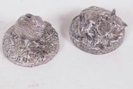 Two small filled silver figurines of animals on circular bases, a rabbit and a mouse under a leaf,