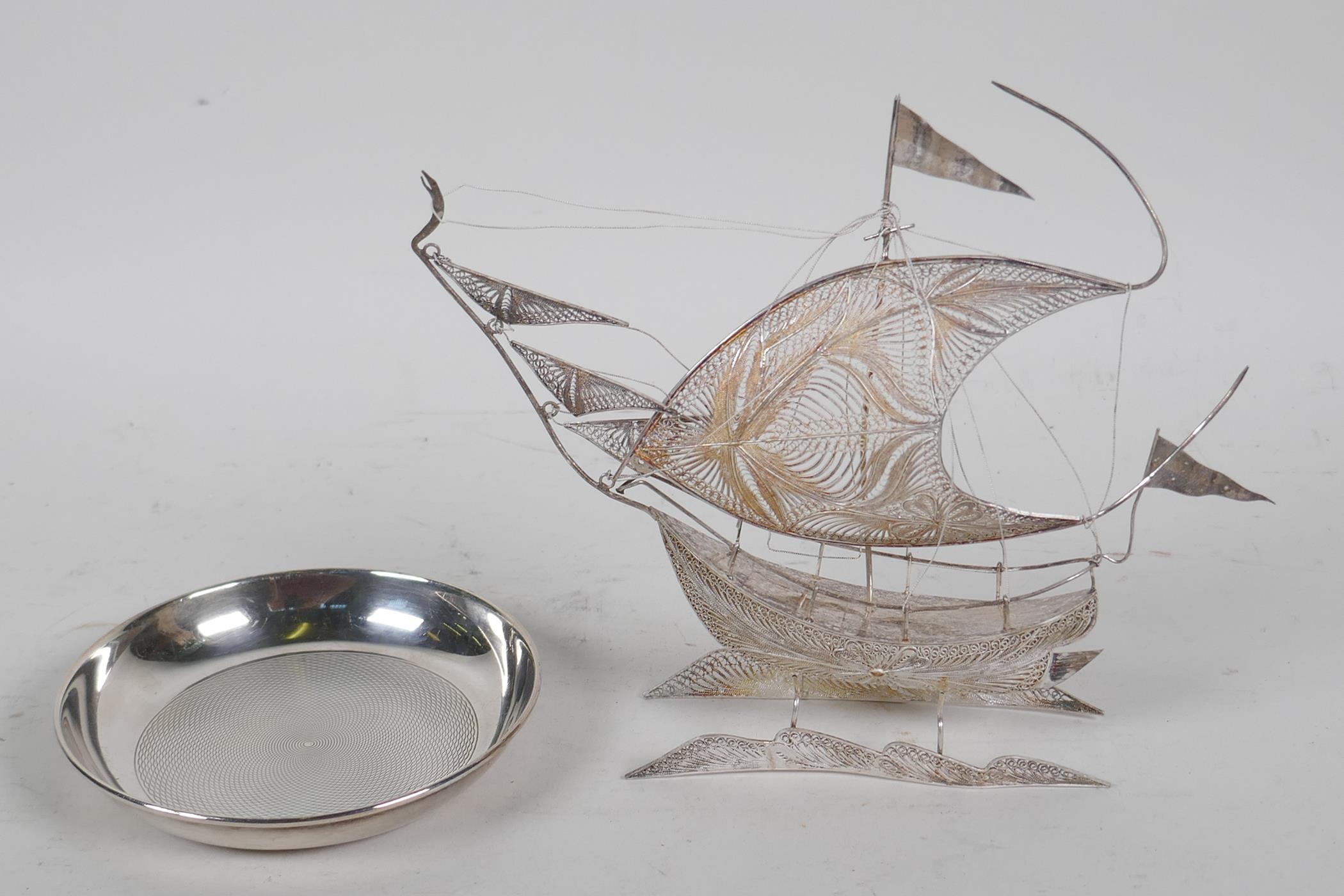 A silver filigree model of a sailing ship, 6½" long, and a small silver pin tray with engine