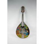 A Russian made flat back mandolin, the body painted with a figure and bird in a tree, signed
