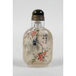 A Chinese reverse decorated glass snuff bottle depicting birds perched on branches in bloom, 3" high
