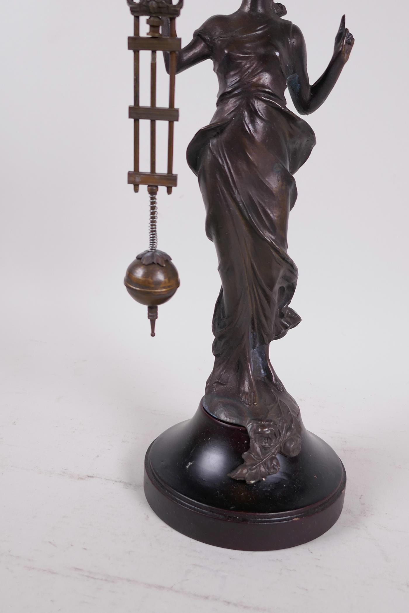 A bronze mystery clock cast as an Art Nouveau style lady with the clock raised on one arm, 13" high - Image 4 of 4