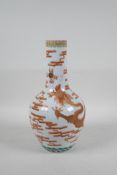 A Chinese polychrome porcelain bottle vase decorated with an iron red and gilt dragon chasing the