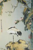 A Chinese polychrome porcelain panel decorated with a crane standing beneath trees in blossom, in