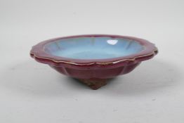 A Chinese Jun ware pottery dish with a lobed rim, flambe glaze and tripod feet, 7" diameter