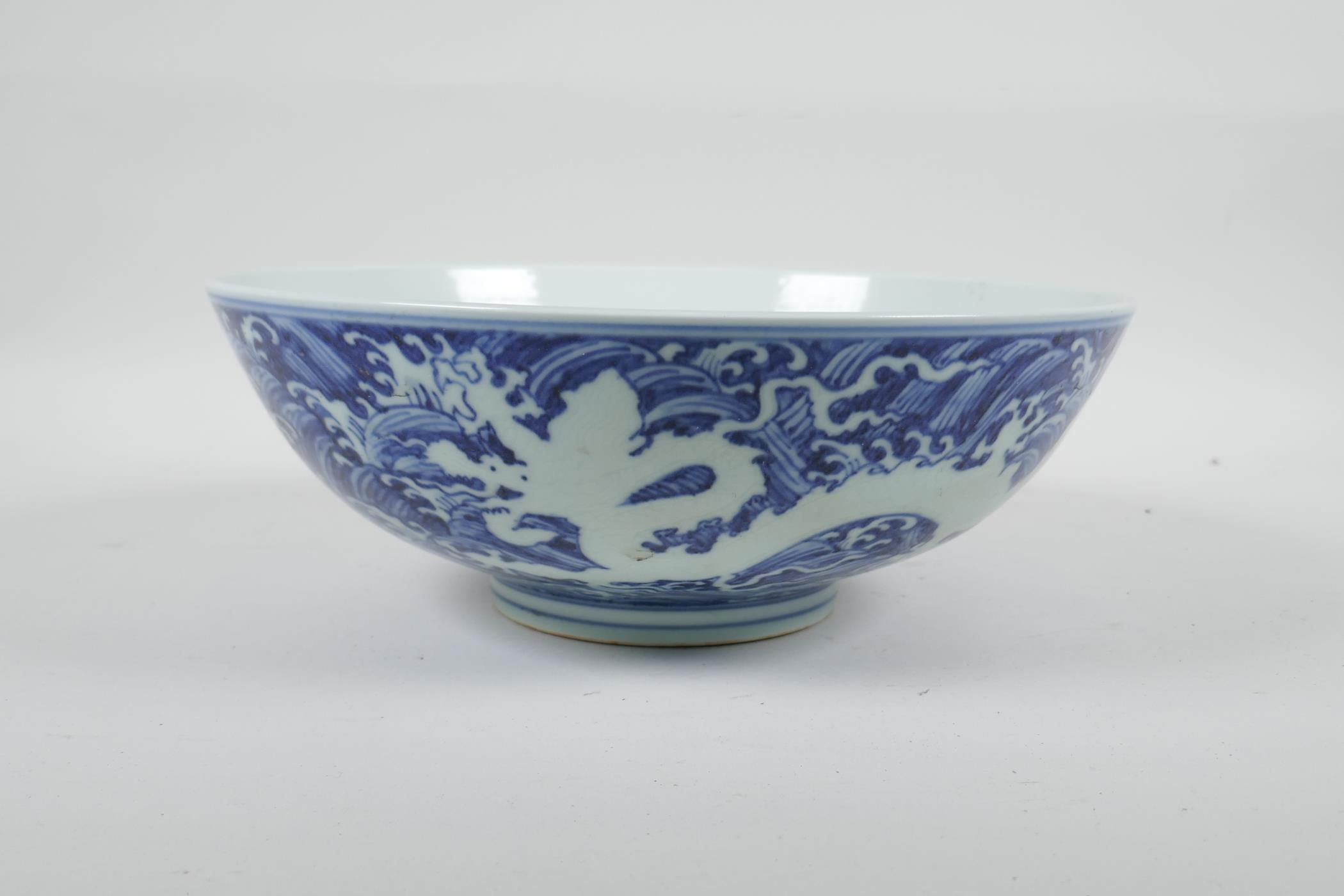 A Chinese blue and white porcelain bowl with twin dragon decoration, 6 character mark to base, 10" - Image 2 of 4