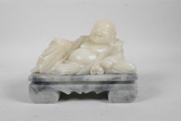 A Chinese carved soapstone figure of a reclining jolly Buddha, 6" long