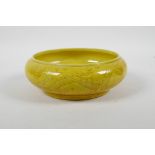 A Chinese yellow glazed porcelain bowl with a rolled rim and incised dragon decoration, 6