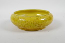 A Chinese yellow glazed porcelain bowl with a rolled rim and incised dragon decoration, 6