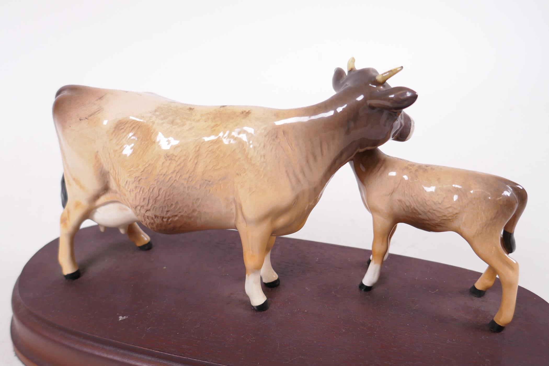 A Beswick figure of a Jersey cow and calf, on a wooden stand, 9½" long, A/F - Image 2 of 3