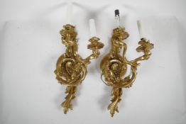 A pair of gilt metal Rococo style twin branch electric wall sconces, 16" high