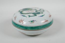 A Chinese famille verte porcelain circular box and cover decorated with a dragon and flaming